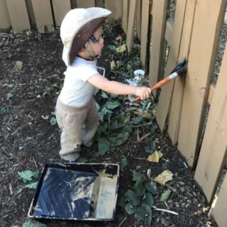 baby painting fence