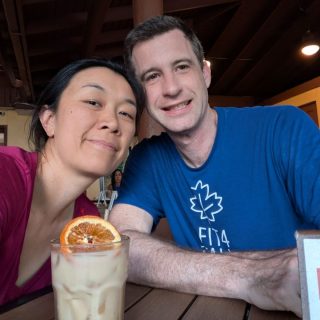 Liuan and Matt take a selfie with a tropical drink.