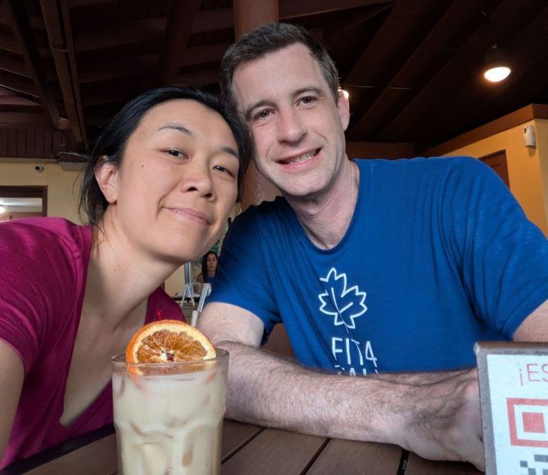 Liuan and Matt take a selfie with a tropical drink.